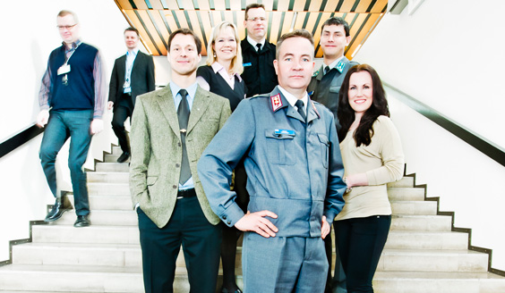 A group photo of Defense Forces personnel on the stairs. Pictured are soldiers as well as civilians, women and men