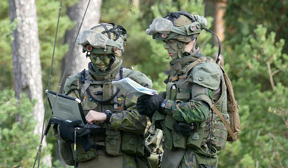 Two soldiers looking at a map and a computer