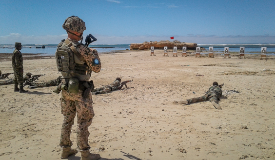 Sotilaita ampumassa maalitauluihin makuulta rannalla