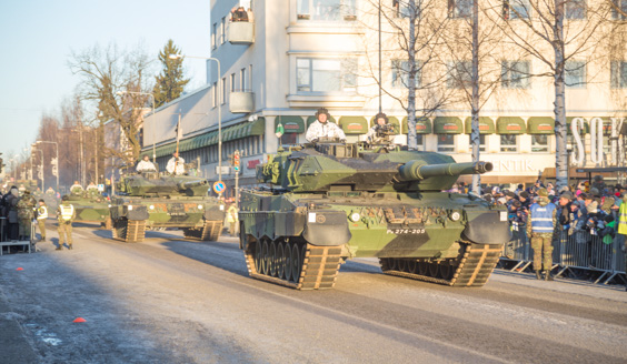 Paraatin ohimarssissa taistelupanssarivaunuja ajaa katua pitkin