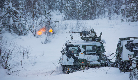  En soldat avfyrar en pistol från taket på ett spårat fordon