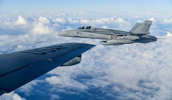 An airplane wing that reads USAF and an adjacent fighter flying