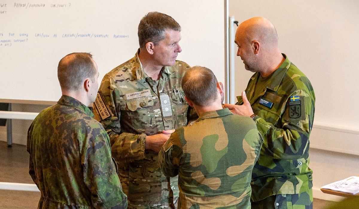 En finländsk, en dansk, en norsk och en svensk soldat samtalar.