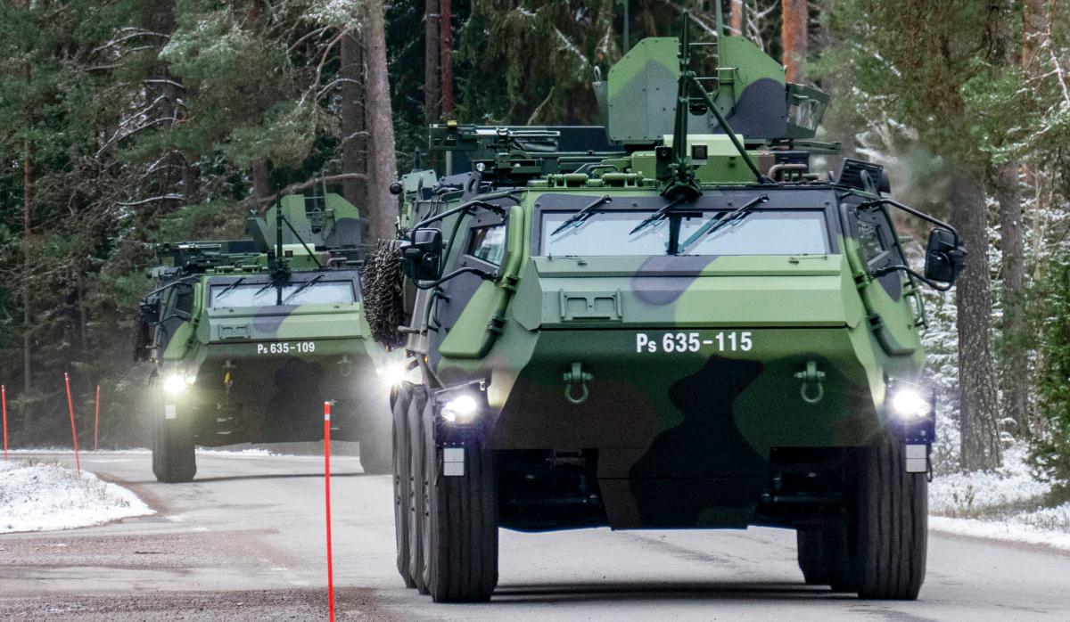 Två XA-300  trupptransportfordon kör på vägen.
