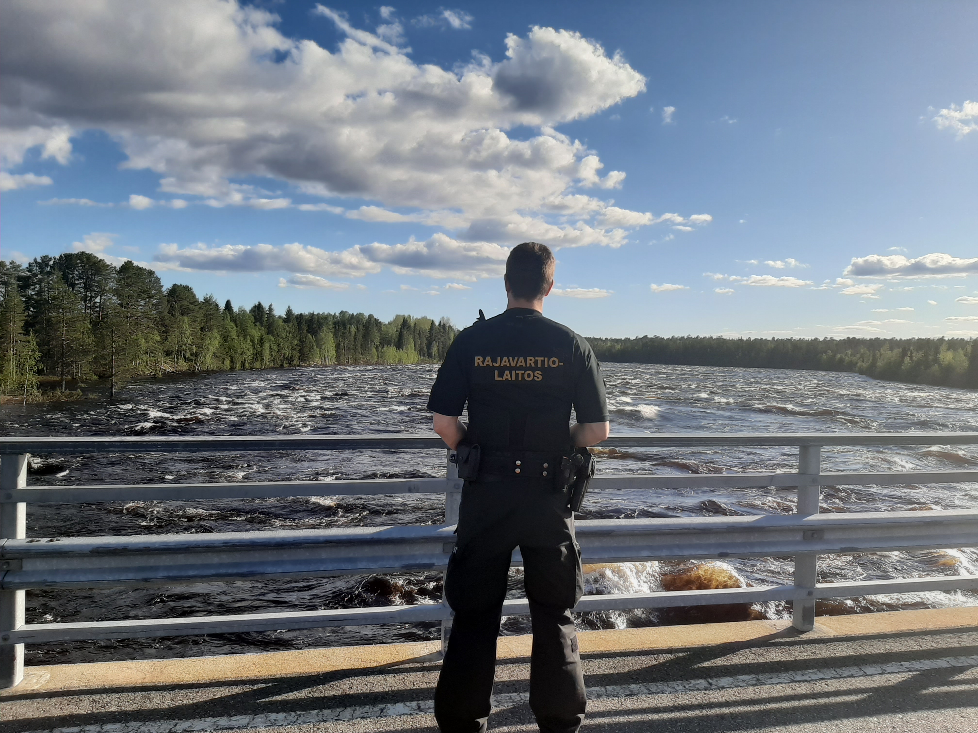 Rajavartija katselee järvimaisemaa.