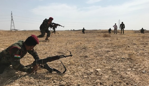 Irakin sotilaita harjoittelemassa taistelua peltoaukealla rynnäkkökiväärit kädessä