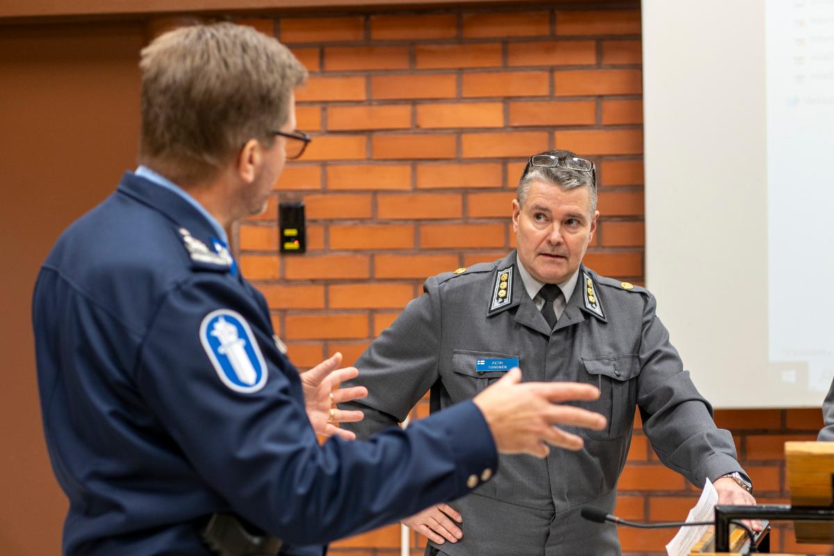 Kansikuvassa sotilas ja poliisi keskustelemassa, toisessa kuvassa sotilas puhumassa yleisölle