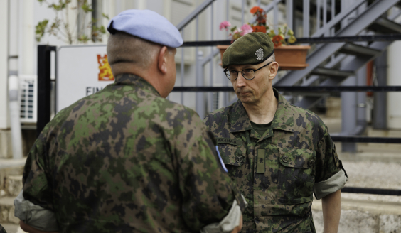 Prikaatikenraali Takamaa kättelemässä suomalaista rauhanturvaajaa.