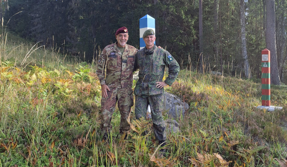 Commanders standing side by side in the terrain.