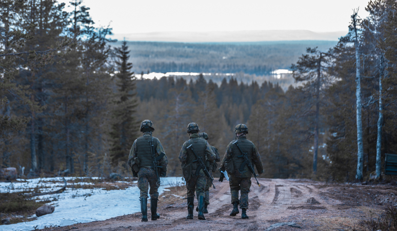 Kolme varusmiestä kävelee Rovajärven harjoitusalueella.