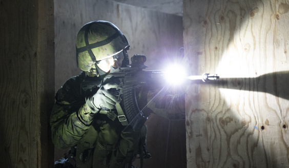 Taistelija tähtäämässä rynnäkkökiväärillä, jossa on asevalo