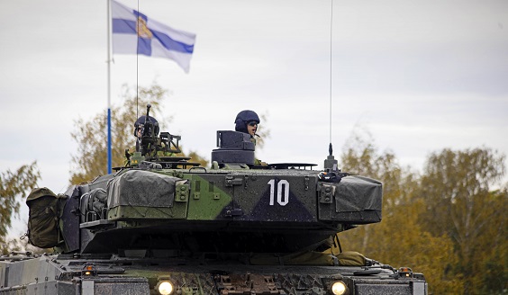 Kuvassa panssarivaunu Haminassa, taustalla Suomen lippu