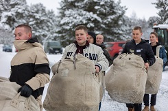 Alokkaat kantavat siviilivaatteissaan suuria varustesäkkejä varusvarastolta kasarmille.