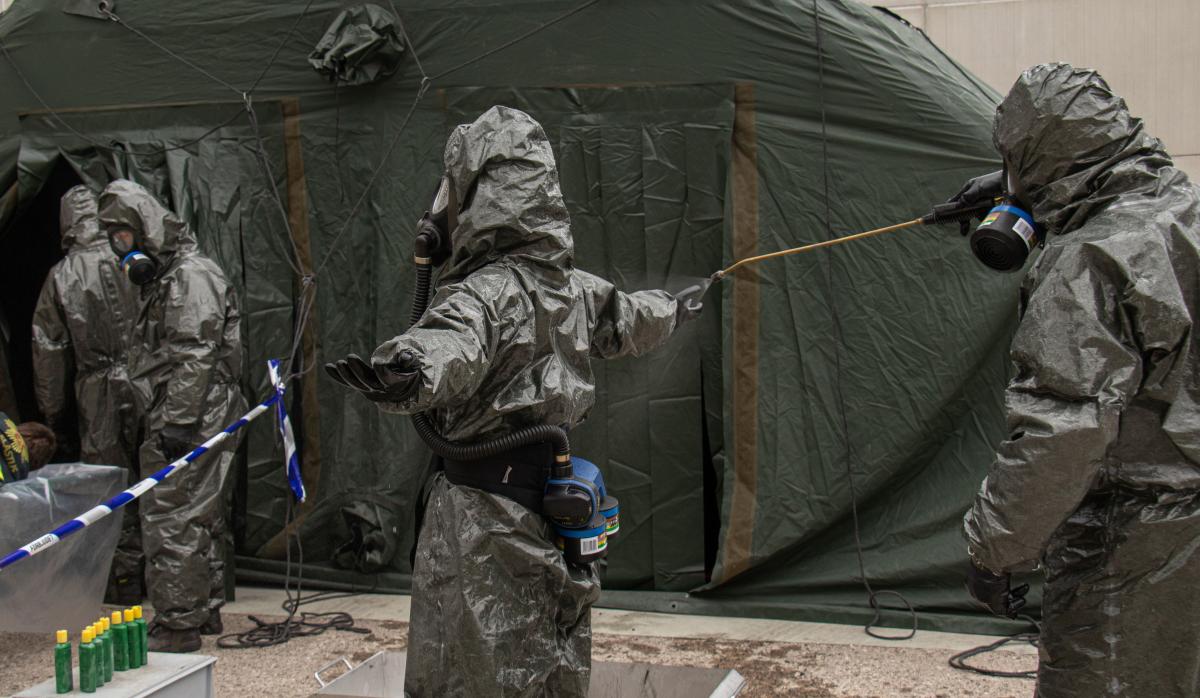 Henkilöitä suoja-asuissa, jotkaharjoittelevat vaarallisten aineiden puhdistamista.