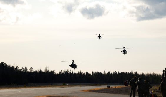 Kolme helikopteria taivaalla tulossa laskuun.