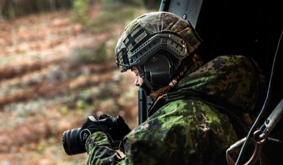 Naissotilas kuvaa kameralla helikopterista ulos