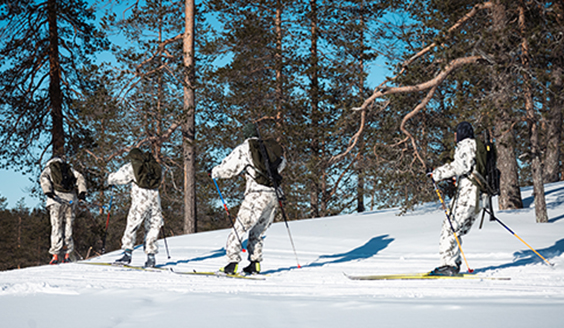 Sotilaita lumipuvuissa hiihtämässä.