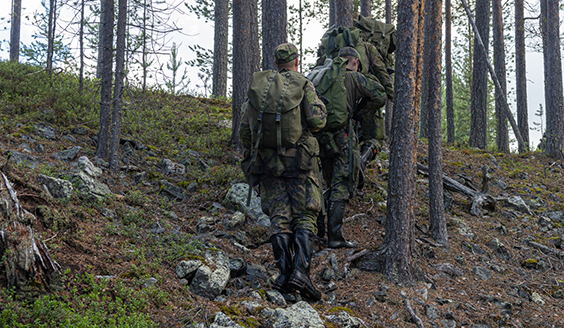 Varusmiehiä kaukopartiomarssilla metsässä.