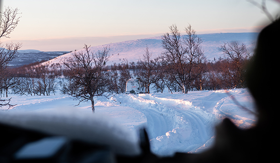 Talvinen maisema, jossa näkyy kaukana telakuorma-auto.
