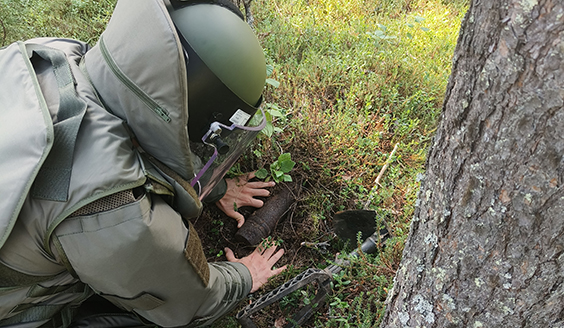 An explosive ordnance disposal specialist in the forest.