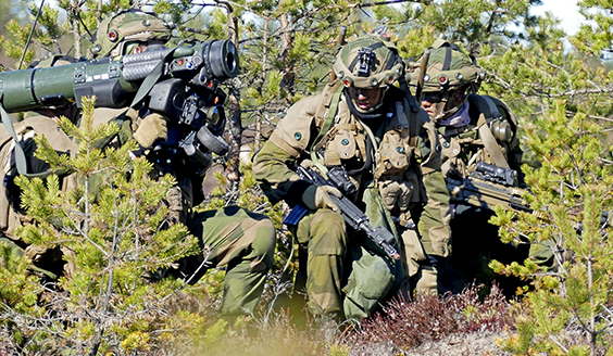 Kolme sotilasta kyykyssä joista yksi tähtää panssaritorjuntaohjuskella