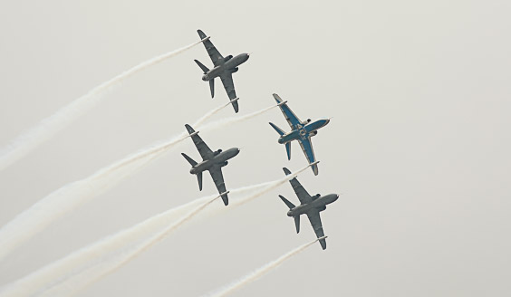 Neljä Hawk-suihkuharjoituskonetta lentää taivaalla tiiviisti vierekkäin.