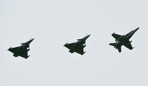 Suomalainen F/A-18 Hornet ja kaksi ranskalaista Rafale-hävittäjää lentää taivaalla