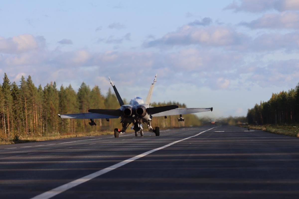 Hornet-hävittäjä kuvattuna takaapäin maantietukikohdan suoralla lähdössä.