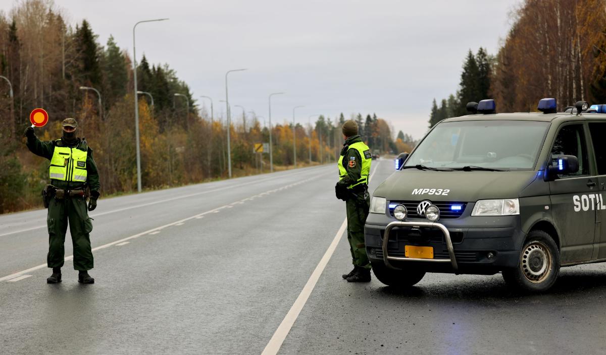 Sotilaspoliisit pysäyttämässä liikennettä maantiellä.