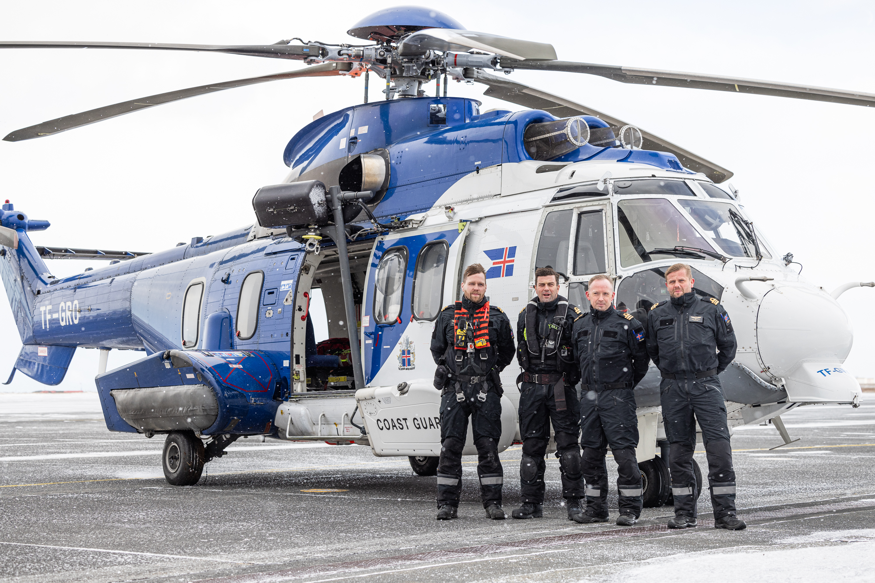 Miehistö seisoo helikopterin edessä.