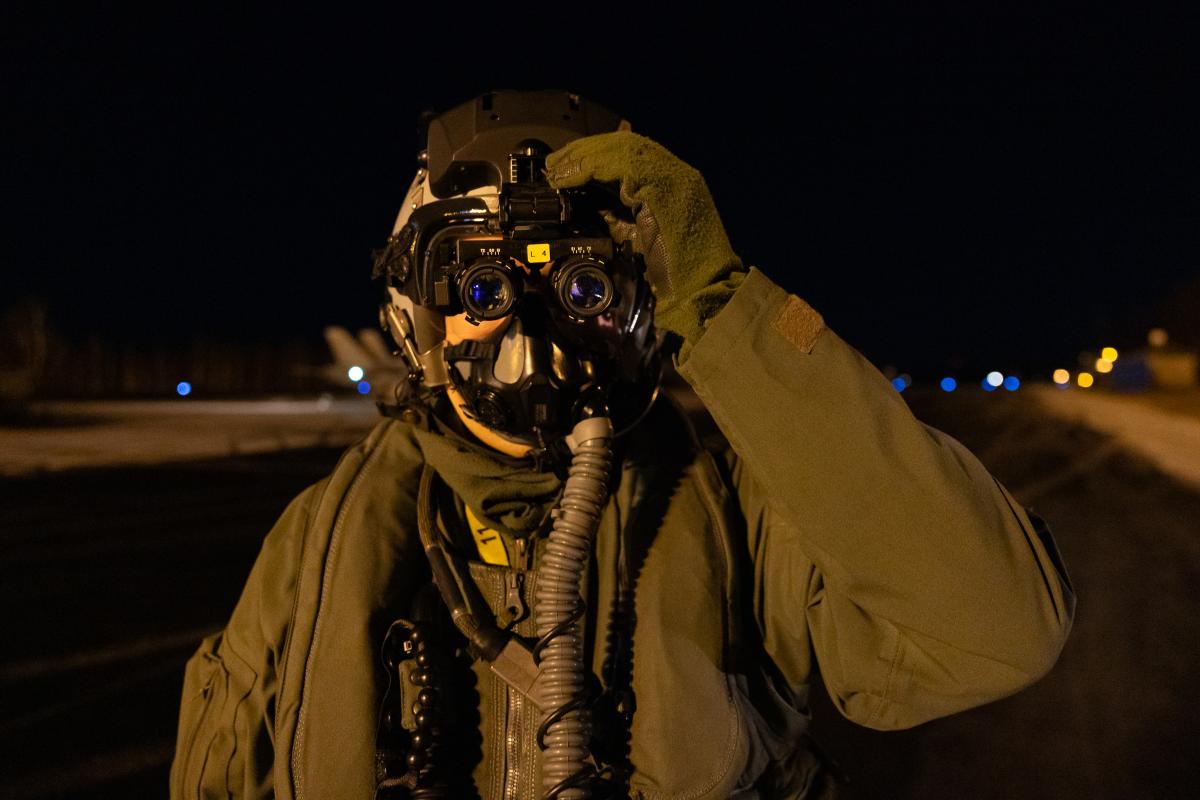 Hävittäjälentäjä katsoo kameraan pimeänäkölasit silmillään.