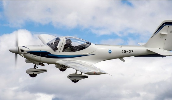 Valkoinen Grob potkurilentokone taivaalla lähikuvassa.