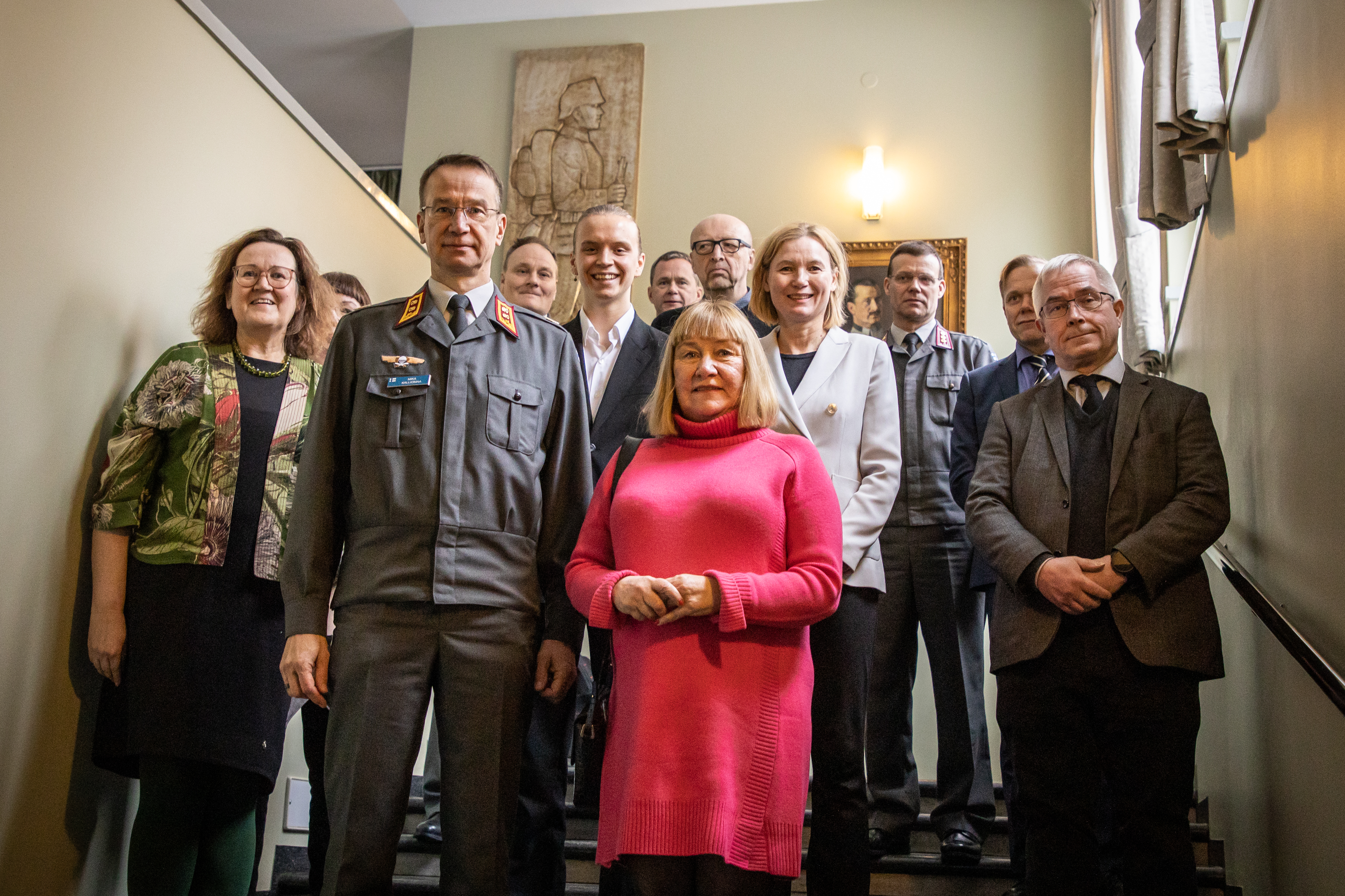 Karvi-arviointiryhmä tutustumassa Maanpuolustuskorkeakouluun. Kuvassa ihmisiä seisomassa rapuilla, kuvassa mm. MPKK:n rehtori, kenraalimajuri Mika Kalliomaa ja auditointiryhmän puheenjohtaja Hanna Snellman.