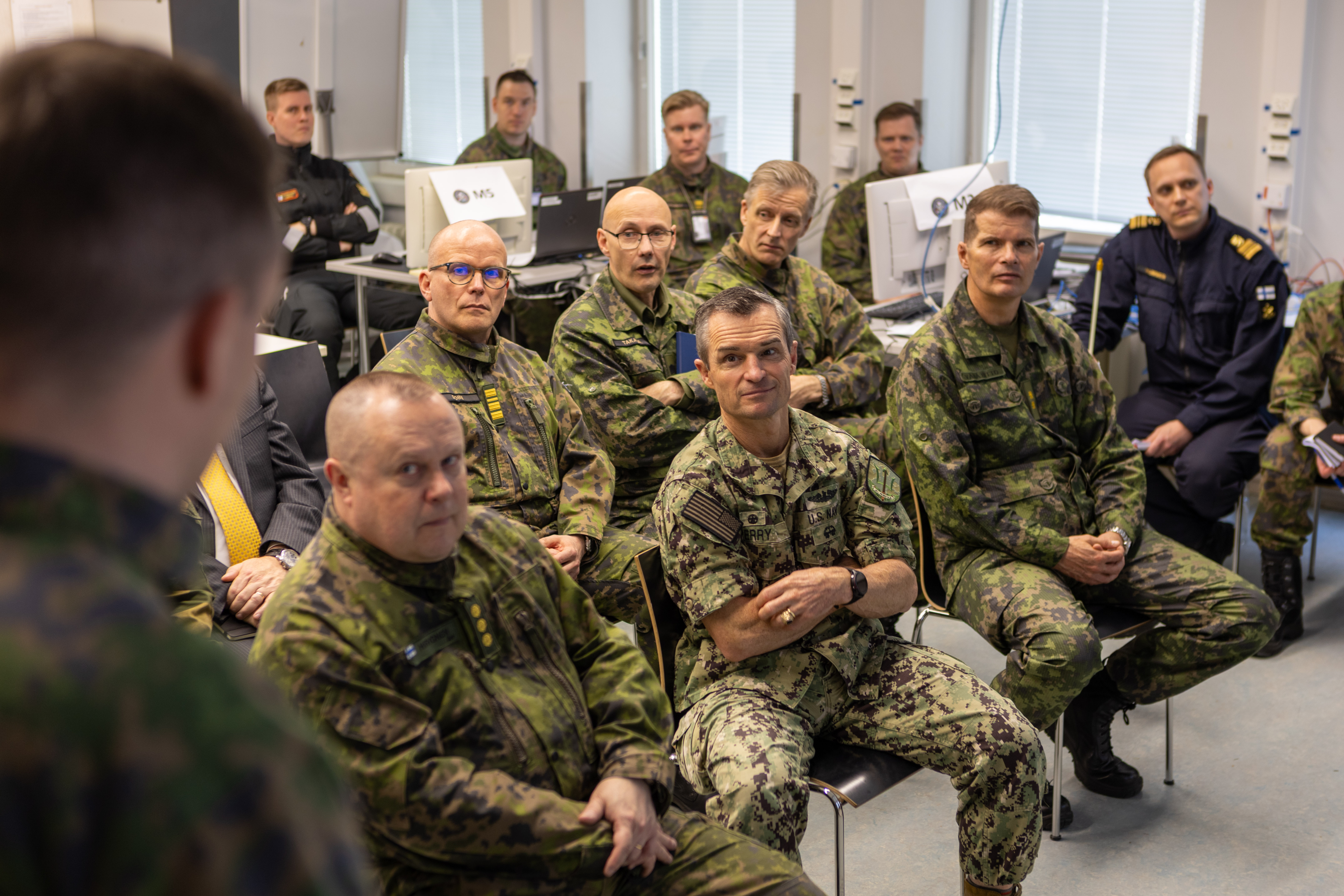 Norfolkin yhteisoperaatioesikunnan yhdysvaltalainen komentaja ja suomalaisia sotilaita seuraamassa opiskelijan esitystä. 