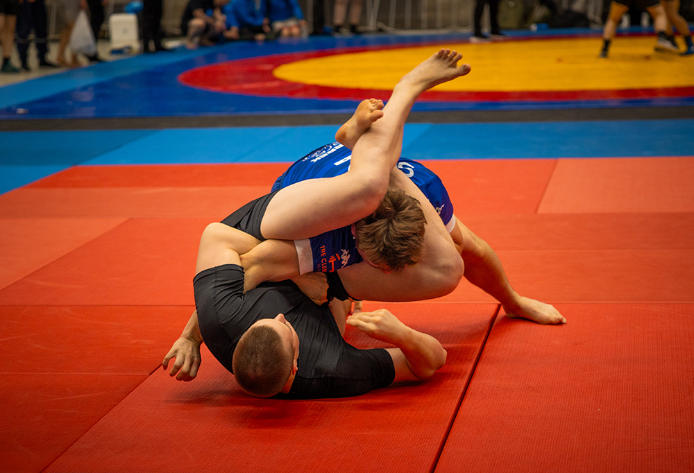 Kaksi varusmiestä kilpailevat lukkopainissa tatamin päällä.