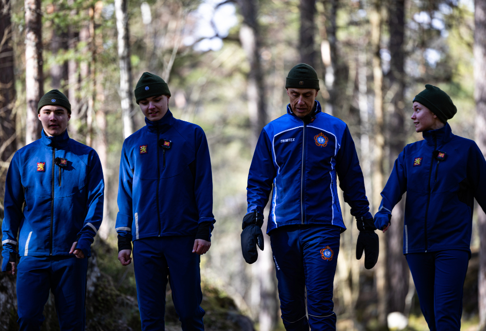 Stubb ja varusmiehet kävelemässä metsässä liikuntakampanjan kuvauksia varten.