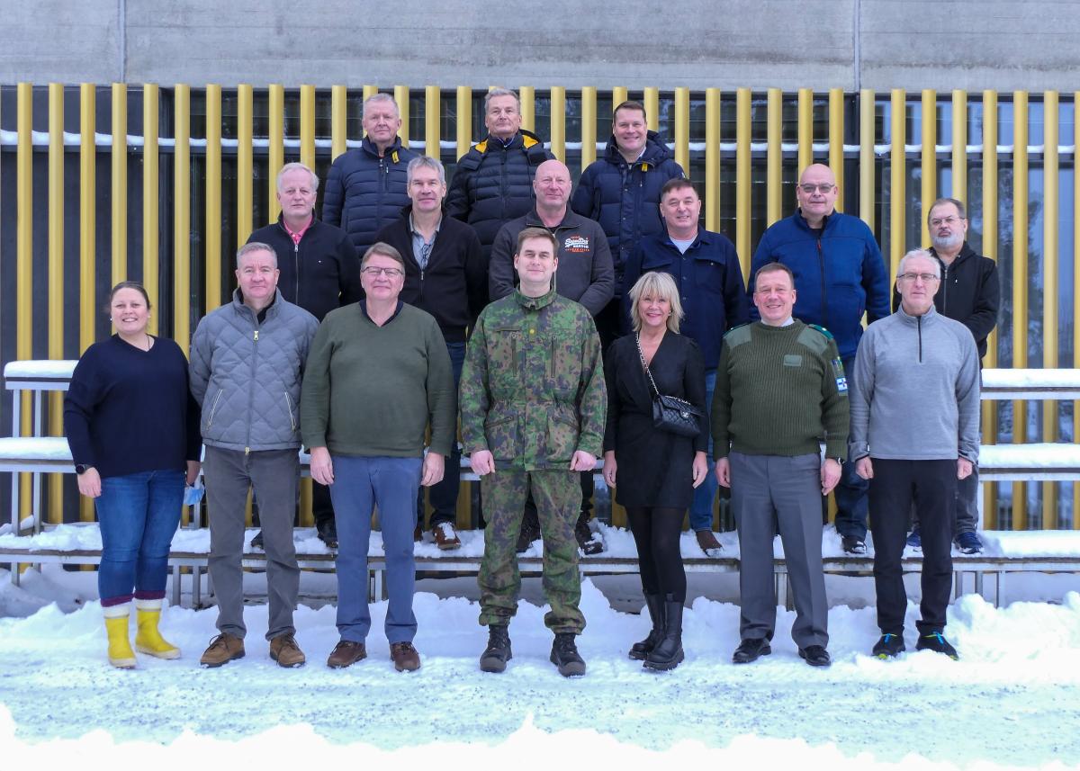 Military and civilian wrkshop participants standing in a group outdoors