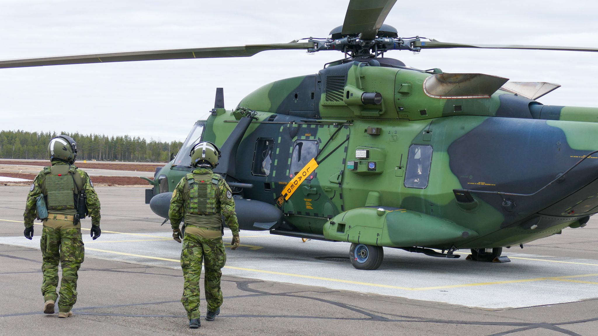 En soldat skjuter bakom ett träd i ett vinterlandskap.