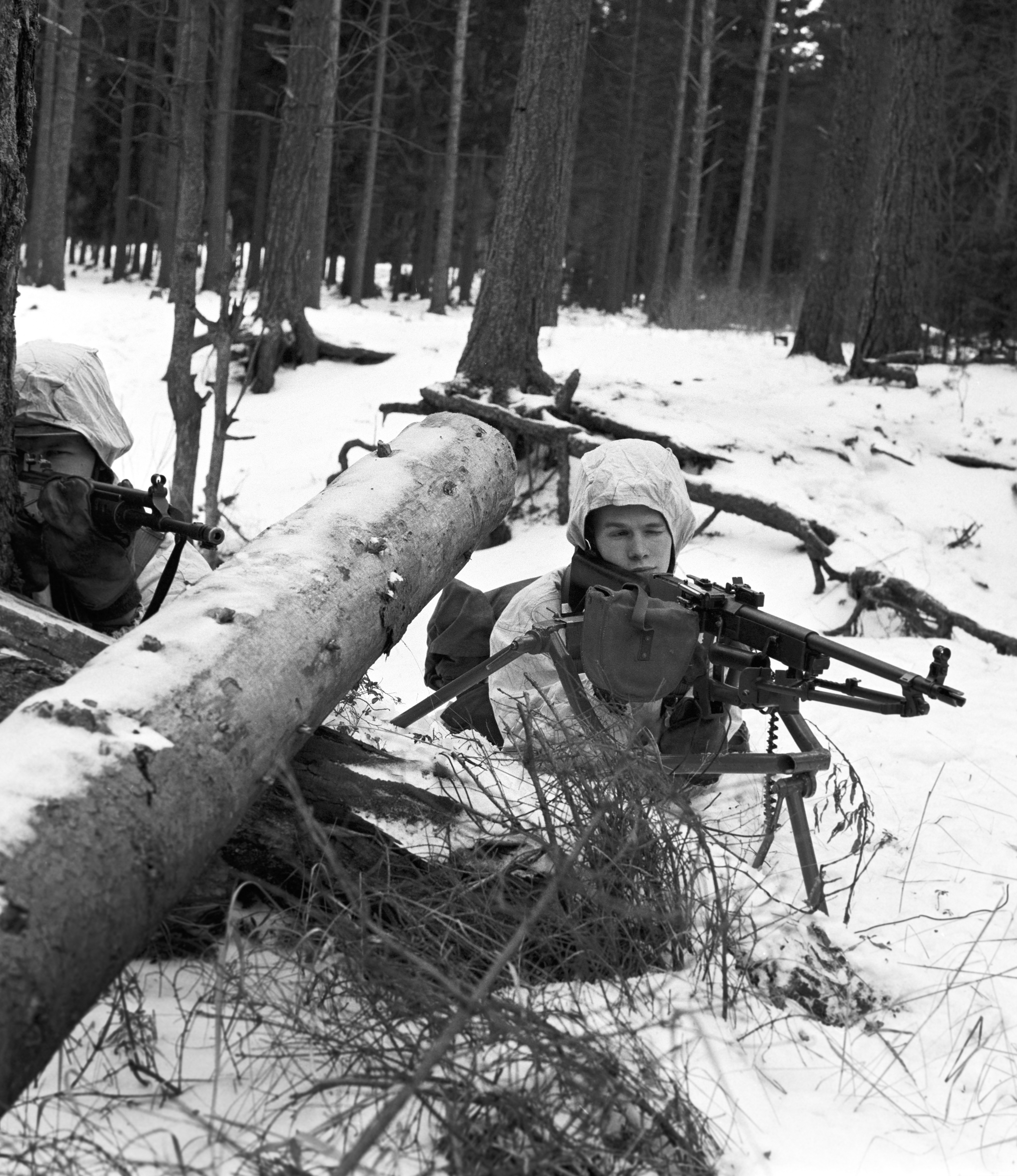 Kaksi sotilasta tähtäilee aseilla talvisessa maastossa, mustavalkokuva